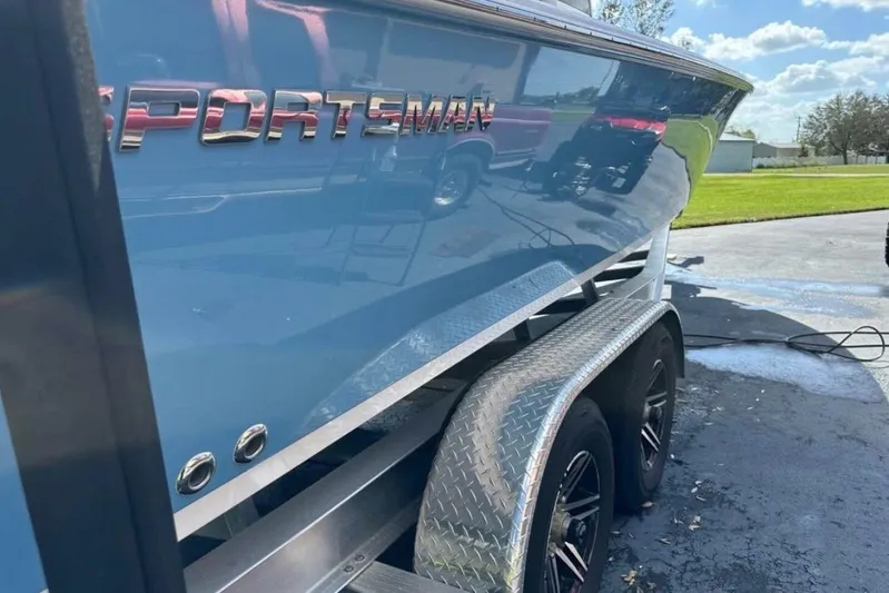  Yacht Photos Pics 2023 Sportsman Masters 267 Bay Boat on trailer, shiny blue hull, sunny day.