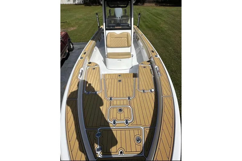  Yacht Photos Pics 2023 Sportsman Masters 267 Bay Boat with tan deck and seating, parked on grass.