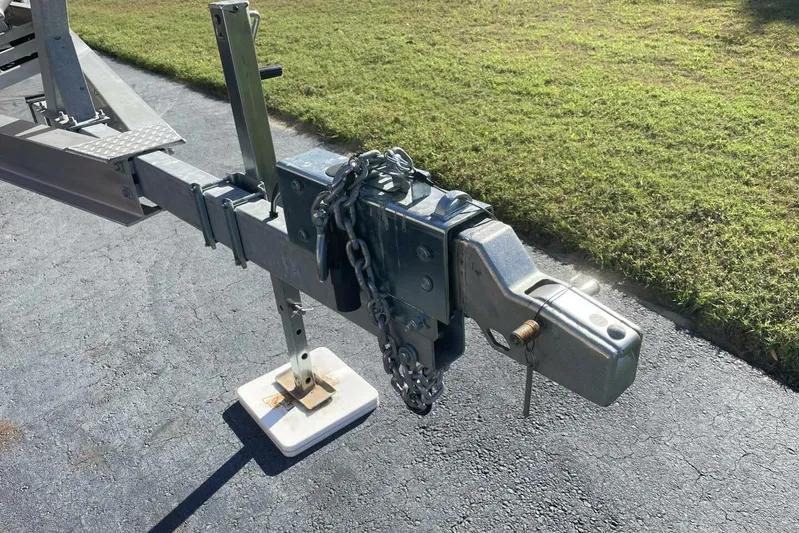  Yacht Photos Pics Trailer hitch of 2023 Sportsman Masters 267 Bay Boat on asphalt, secured with chains.