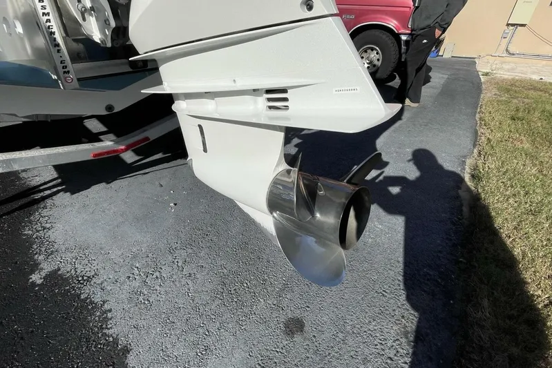  Yacht Photos Pics 2023 Sportsman Masters 267 Bay Boat propeller and engine detail on a driveway.
