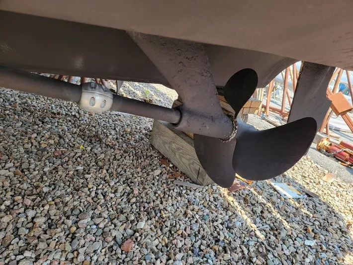  Yacht Photos Pics Propeller of 2006 Tiara Yachts 3200 Open on gravel surface.