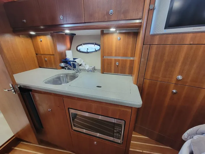  Yacht Photos Pics 2006 Tiara Yachts 3200 Open galley with wood cabinetry, sink, and microwave.