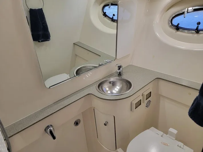  Yacht Photos Pics 2006 Tiara Yachts 3200 Open bathroom with sink, mirror, and porthole window.