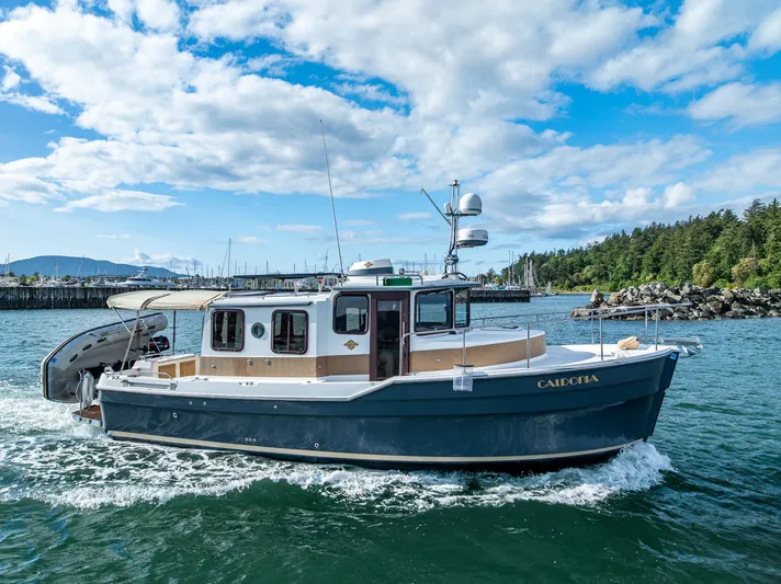 Caldonia Yacht Photos Pics 2013 Ranger Tugs R 29 boat cruising on a sunny day near a marina.