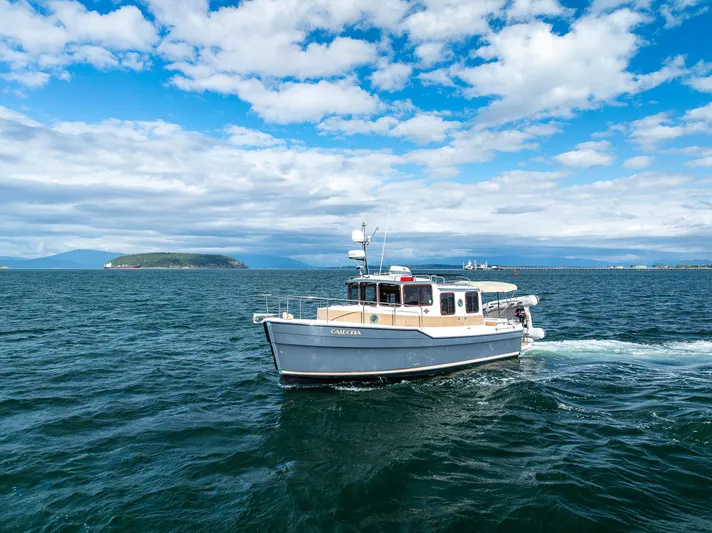 Caldonia Yacht Photos Pics 2013 Ranger Tugs R 29 cruising on open water under a partly cloudy sky.