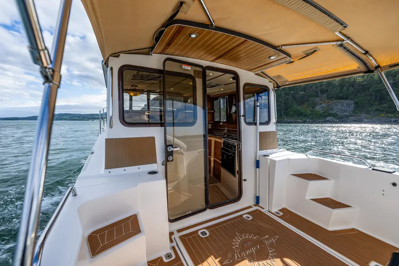 Caldonia Yacht Photos Pics 2013 Ranger Tugs R 29 boat deck with open cabin door, scenic water view.