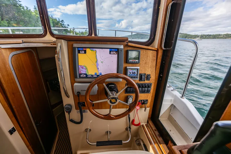Caldonia Yacht Photos Pics Pilothouse of 2013 Ranger Tugs R 29 with navigation display and wooden steering wheel.