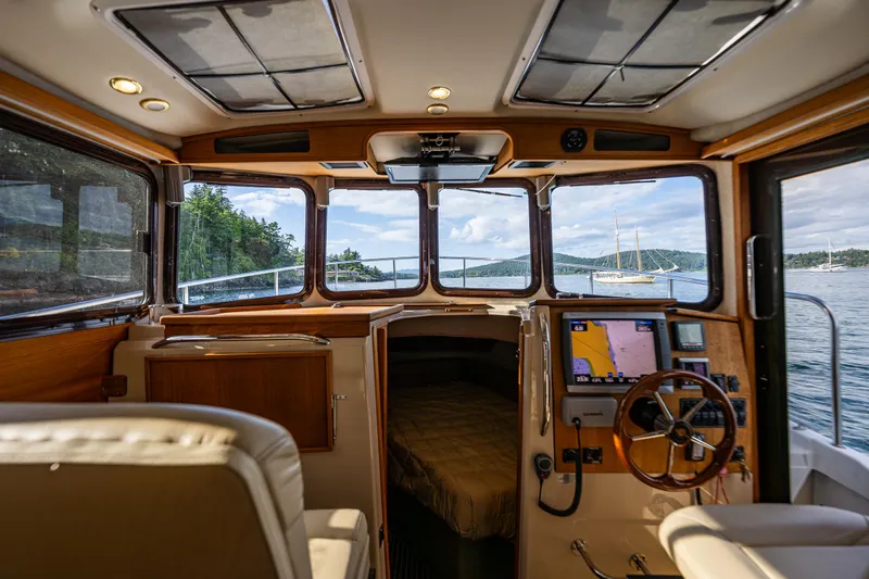 Caldonia Yacht Photos Pics Interior view of 2013 Ranger Tugs R 29 boat, featuring helm and cabin with scenic water view.