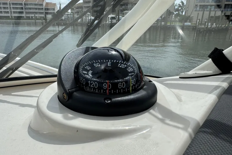 That's What She Said Yacht Photos Pics Compass on 2023 Grady-White Freedom 285 boat dashboard, with waterfront view.