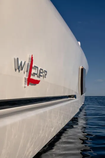  Yacht Photos Pics 2024 Wider Wilder 60 yacht on calm sea, showcasing sleek design and logo.