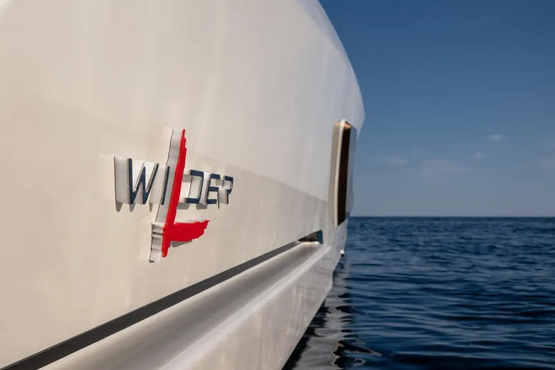  Yacht Photos Pics 2024 Wider Wilder 60 yacht on calm sea, showcasing sleek design and logo.