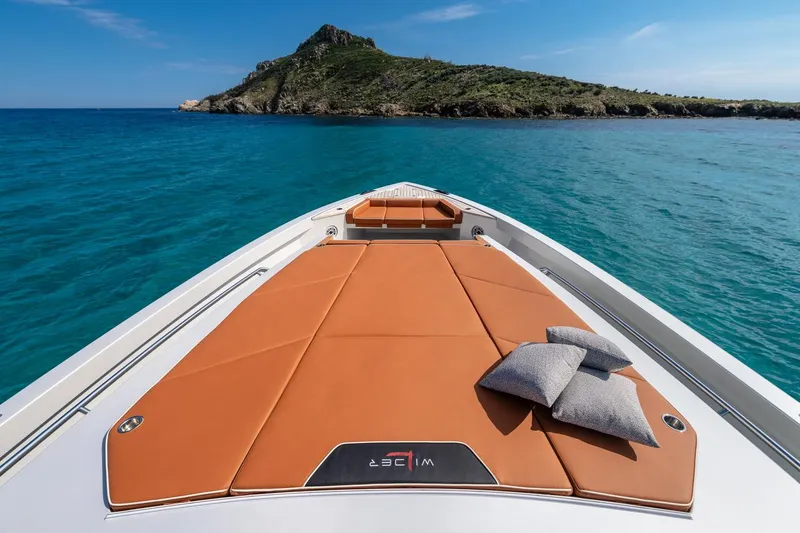  Yacht Photos Pics 2024 Wider Wilder 60 yacht with sunbathing deck, cushions, and scenic island view.