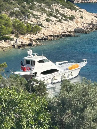 Caraibi Yacht Photos Pics 2013 Hatteras GT63 yacht anchored in a scenic coastal bay.