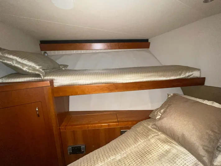 Caraibi Yacht Photos Pics 2013 Hatteras GT63 cabin with wooden bunk beds and beige bedding.