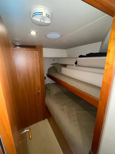 Caraibi Yacht Photos Pics Bunk beds in 2013 Hatteras GT63 yacht cabin with wooden door and smoke detector.