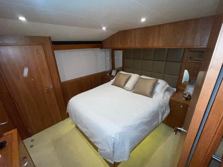Caraibi Yacht Photos Pics Luxurious bedroom interior of 2013 Hatteras GT63 yacht with wooden accents and cozy bedding.