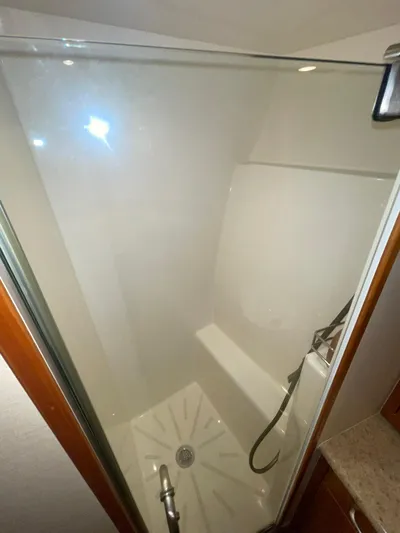 Caraibi Yacht Photos Pics Shower area in 2013 Hatteras GT63 yacht with glass door and modern fixtures.