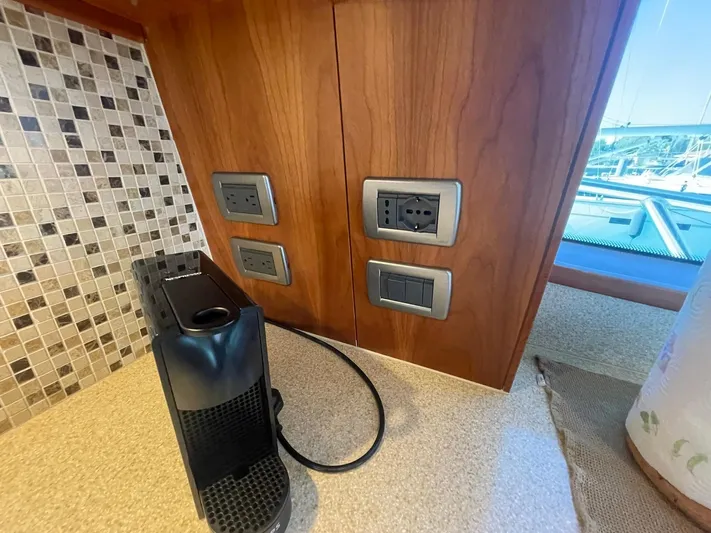 Caraibi Yacht Photos Pics Power outlets and coffee machine on Hatteras GT63 yacht, 2013 model, with tiled backsplash.