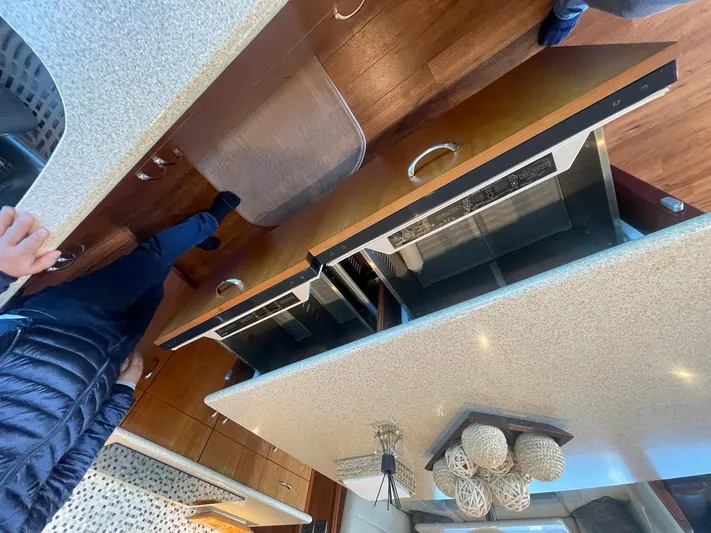 Caraibi Yacht Photos Pics Interior of 2013 Hatteras GT63 yacht kitchen with modern appliances and wooden cabinetry.