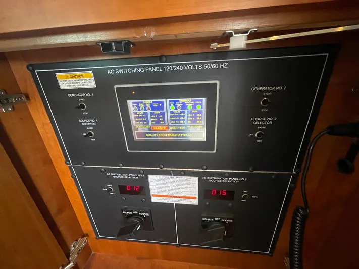Caraibi Yacht Photos Pics AC switching panel on 2013 Hatteras GT63 yacht, displaying voltage and generator controls.