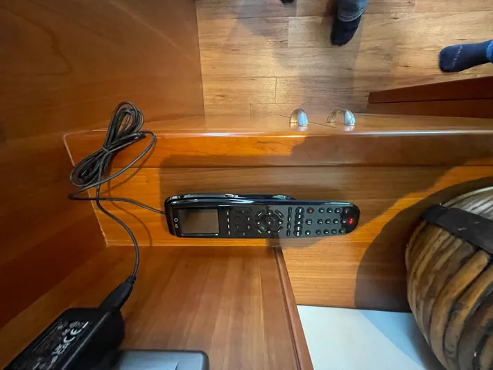 Caraibi Yacht Photos Pics Remote control on wooden surface inside 2013 Hatteras GT63 yacht interior.