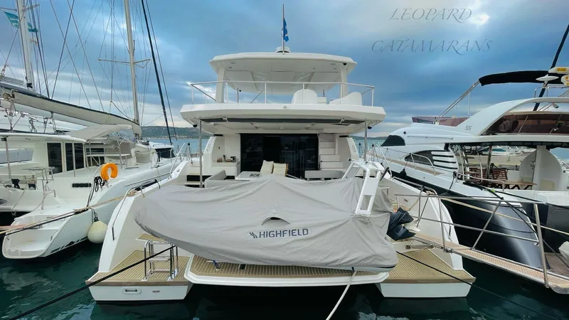  Yacht Photos Pics 2023 Leopard 53 catamaran docked at marina, featuring covered Highfield tender.