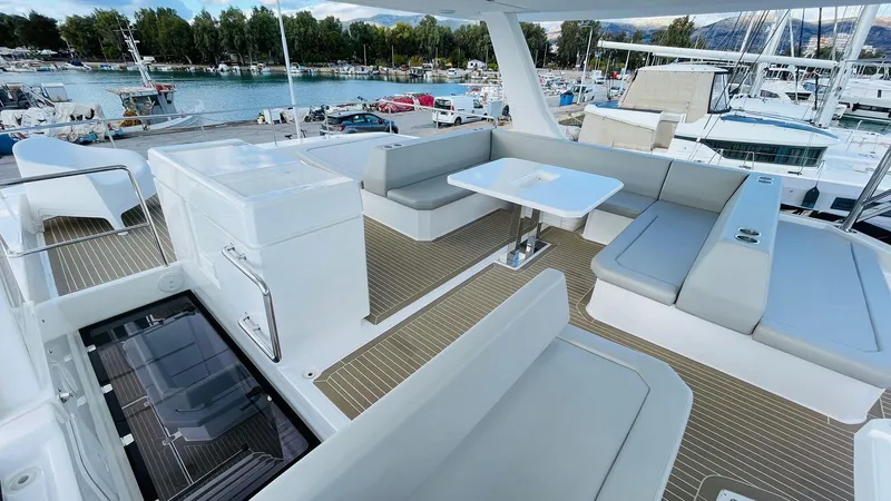  Yacht Photos Pics Luxurious 2023 Leopard 53 yacht deck with seating and table, docked at marina.