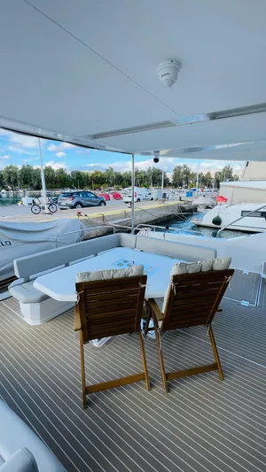  Yacht Photos Pics Luxury Leopard 53 yacht deck with chairs, table, and marina view, 2023 model.