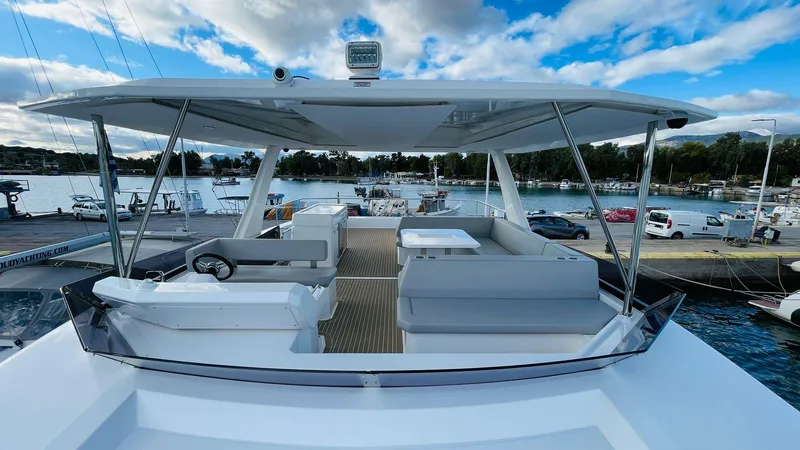  Yacht Photos Pics 2023 Leopard 53 yacht with spacious deck, docked at marina under blue sky.