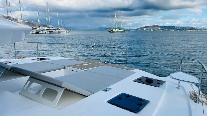  Yacht Photos Pics 2023 Leopard 53 yacht on serene waters with distant sailboats and mountains.