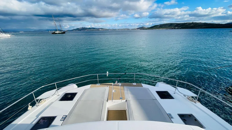  Yacht Photos Pics Front deck view of 2023 Leopard 53 yacht on calm sea under cloudy sky.