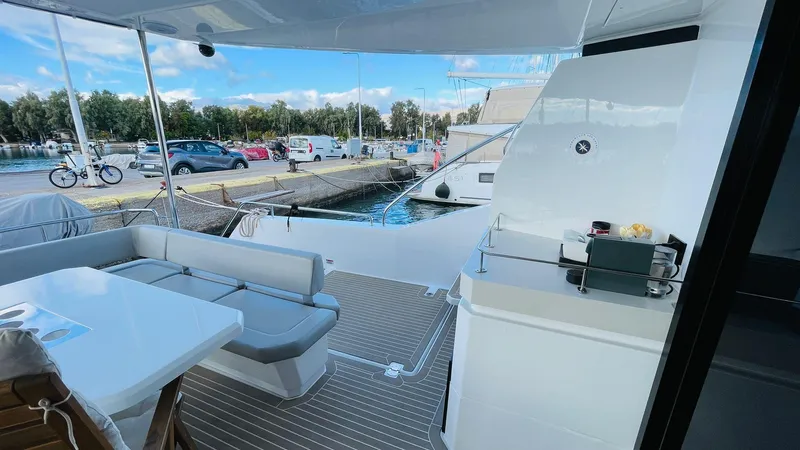  Yacht Photos Pics 2023 Leopard 53 yacht deck with seating and outdoor kitchen, docked at marina.