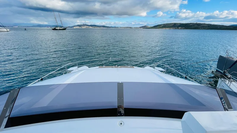  Yacht Photos Pics Front view of a 2023 Leopard 53 yacht on calm waters under a cloudy sky.