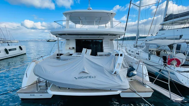  Yacht Photos Pics 2023 Leopard 53 yacht docked, featuring a covered Highfield tender, under a partly cloudy sky.