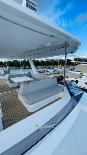  Yacht Photos Pics 2023 Leopard 53 yacht with spacious deck, modern seating, and scenic marina view.