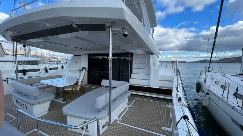  Yacht Photos Pics Luxurious 2023 Leopard 53 yacht with spacious deck and seating, docked at marina.