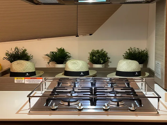  Yacht Photos Pics Modern kitchen with gas stove, straw hats, and potted plants on Leopard 53 yacht, 2023 model.