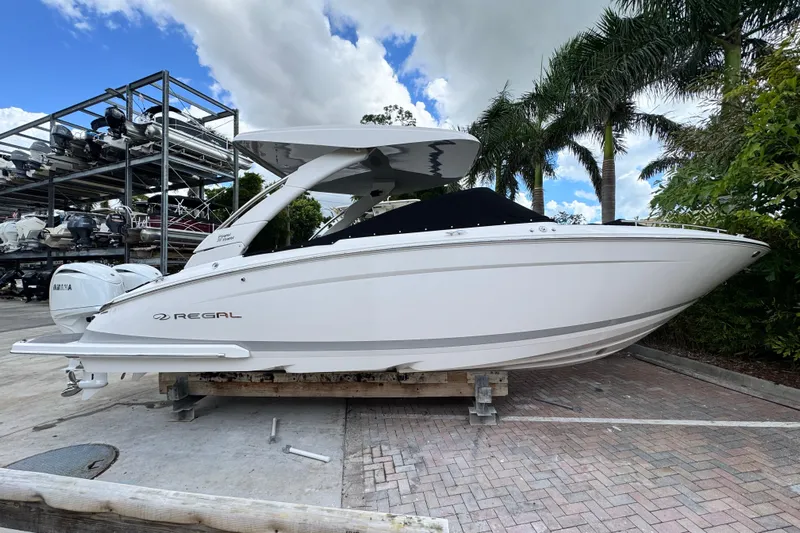  Yacht Photos Pics 2024 Regal LX9 boat on display, surrounded by palm trees and a clear sky.