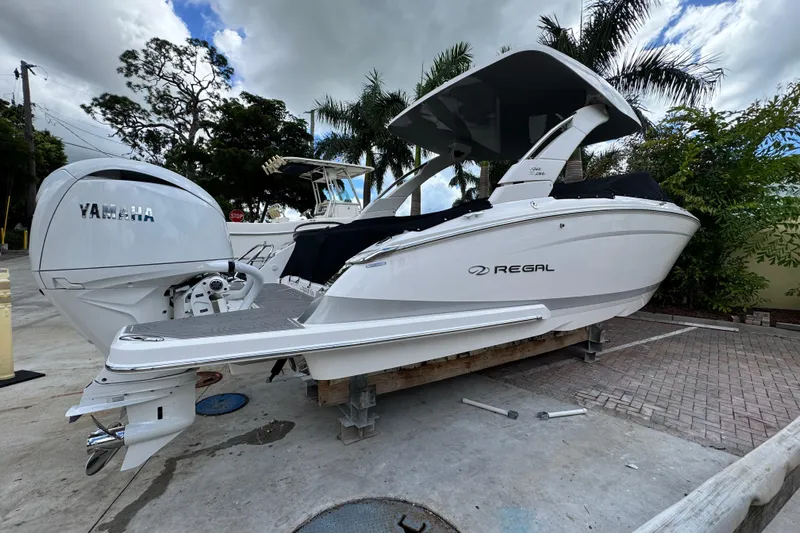  Yacht Photos Pics 2024 Regal LX9 boat with Yamaha engine, parked outdoors under cloudy sky.