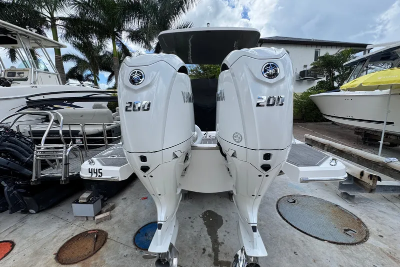  Yacht Photos Pics 2024 Regal LX9 boat with dual Yamaha 200 engines, docked near palm trees.