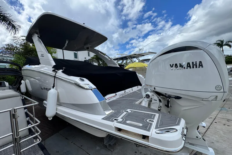  Yacht Photos Pics 2024 Regal LX9 boat with Yamaha engine, docked under a cloudy sky.