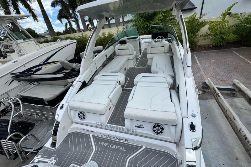  Yacht Photos Pics 2024 Regal LX9 boat with spacious seating and sleek design, docked in a marina.