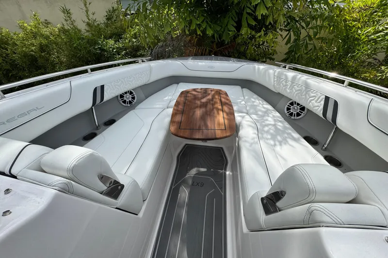  Yacht Photos Pics Luxurious 2024 Regal LX9 boat interior with sleek seating and wooden table.