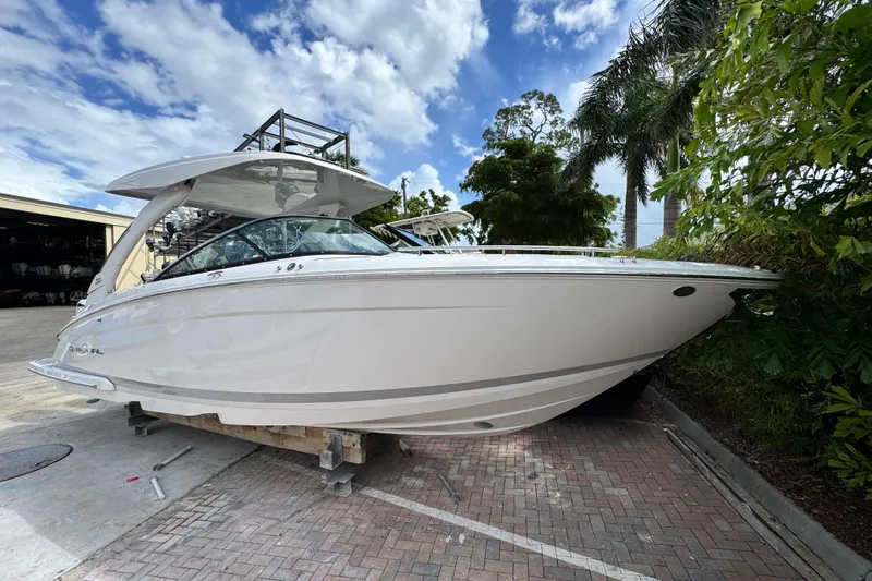  Yacht Photos Pics 2024 Regal LX9 boat displayed outdoors, surrounded by lush greenery and a clear sky.