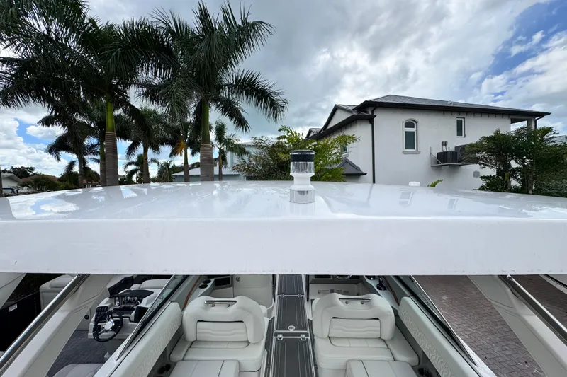  Yacht Photos Pics 2024 Regal LX9 boat with sleek white interior, palm trees, and cloudy sky backdrop.