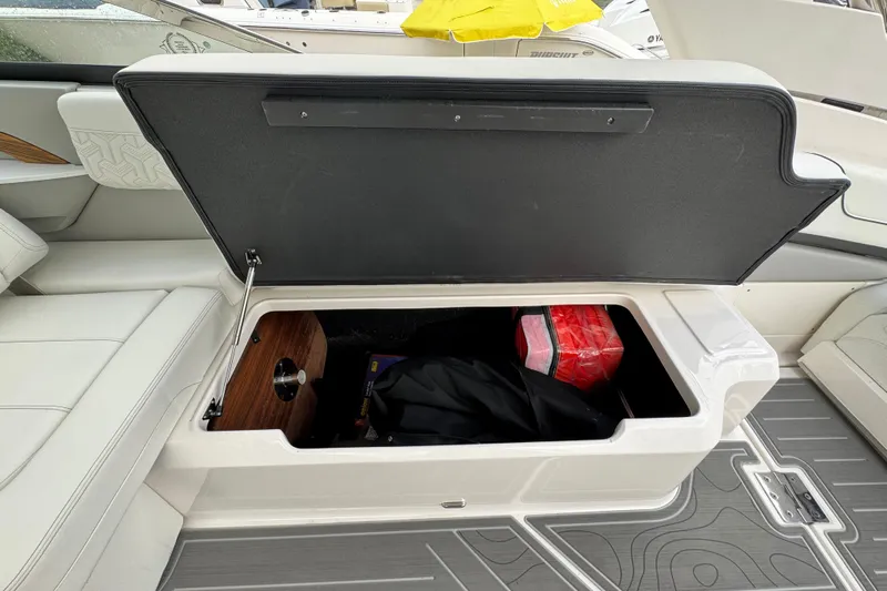  Yacht Photos Pics 2024 Regal LX9 boat interior storage compartment with open lid, revealing stored items.