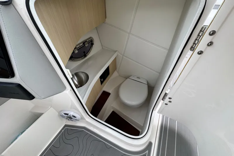  Yacht Photos Pics 2024 Regal LX9 boat interior with compact bathroom, featuring a toilet and sink.