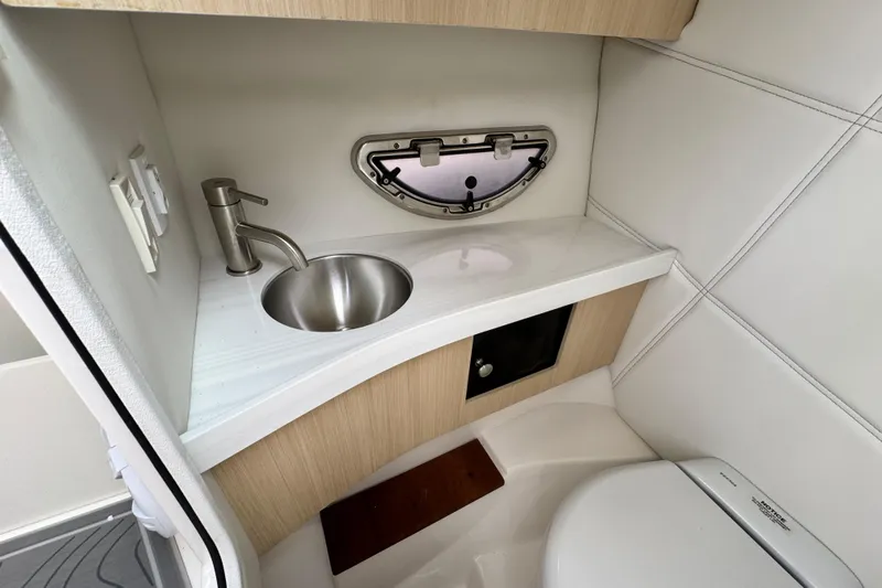  Yacht Photos Pics 2024 Regal LX9 boat bathroom with sink, faucet, and compact toilet.