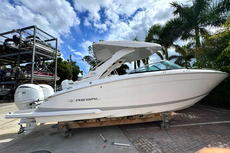  Yacht Photos Pics 2024 Regal LX9 boat on display, surrounded by palm trees and a clear sky.