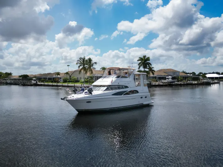  Yacht Photos Pics 2005 Carver 390 MY yacht on a serene waterway with palm trees and cloudy sky.